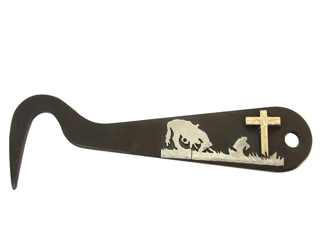 Decorative hoof pick with engraved designs on a white background
