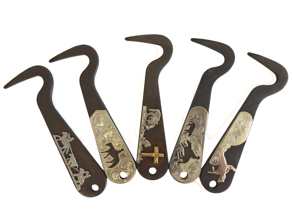 Set of five metal hoof picks with decorative engravings on a white background