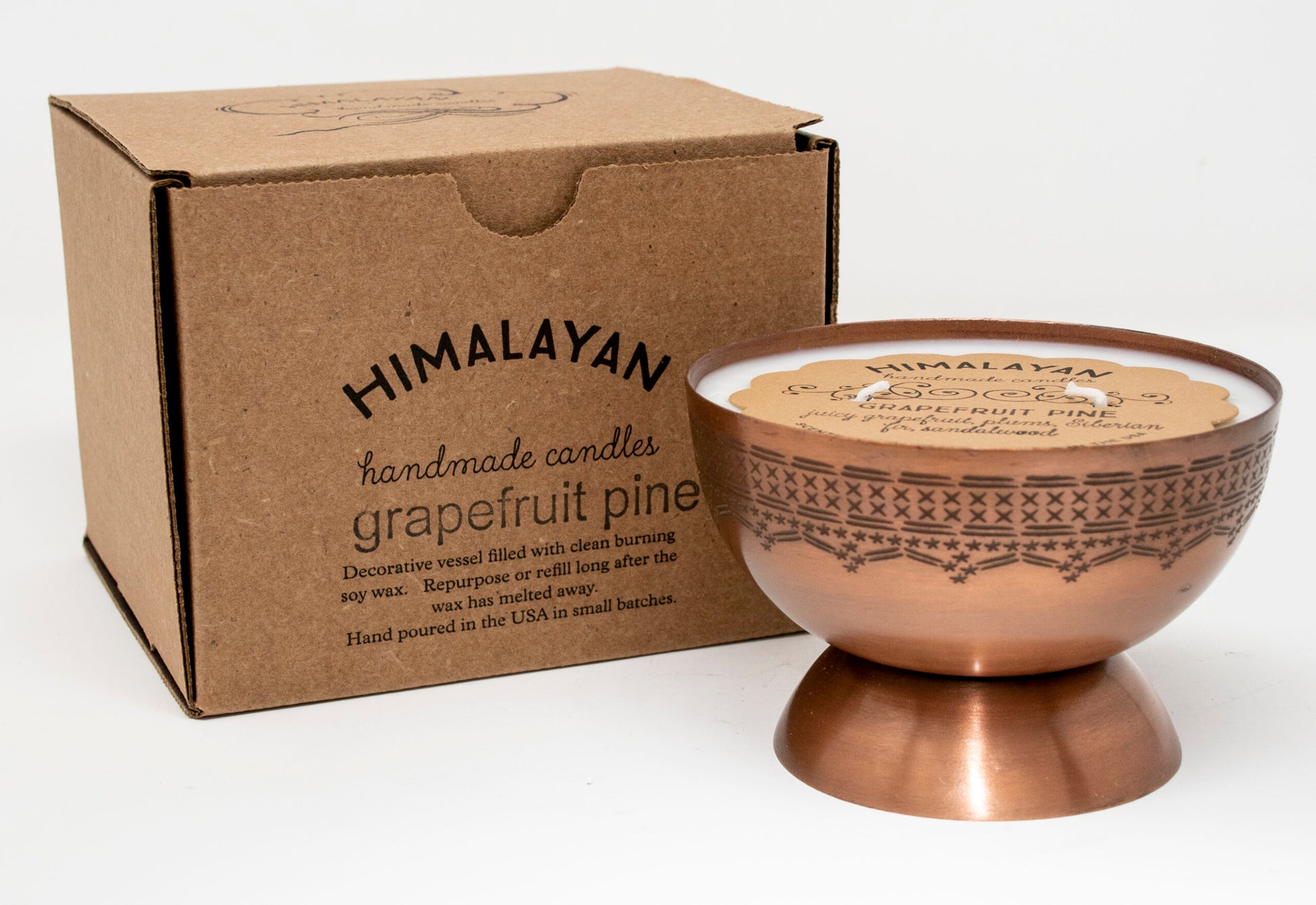 Himalayan handmade candles grapefruit branded cardboard box with bronze candle in a bowl shape with pedestal on a white background