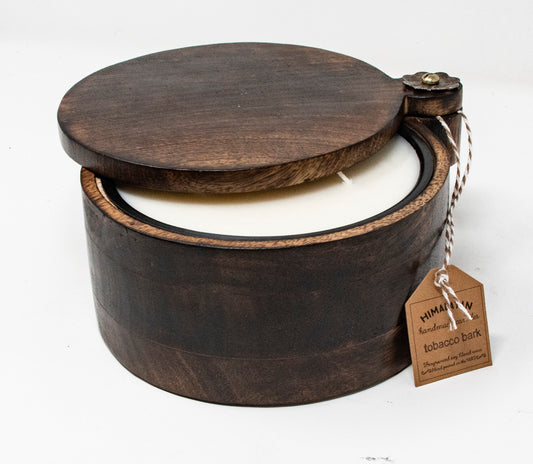 Wooden container with a candle inside and a tag on a white background