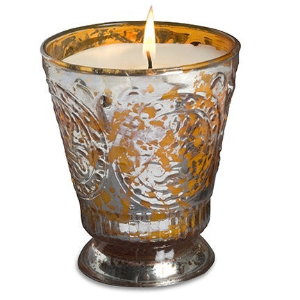 Decorative candle in a silver and gold holder on a white background
